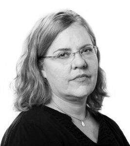 Jennifer LaFleur, a woman with medium-length wavy blonde hair and glasses, is looking into the camera. She is wearing a dark blouse and a necklace against a plain white background.